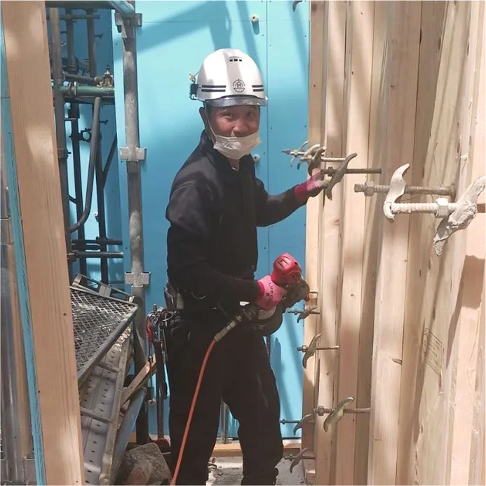 屋外で鉄パイプを持つ作業員