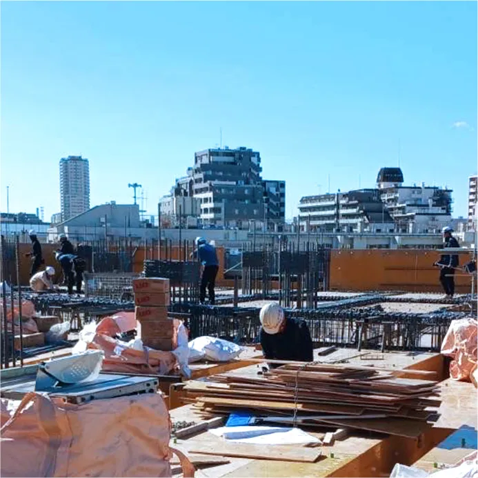 屋外で鉄パイプを持つ作業員