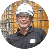 笑顔でヘルメットをかぶる酒井新一職長