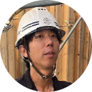 笑顔でヘルメットをかぶる藤村孝秀職長